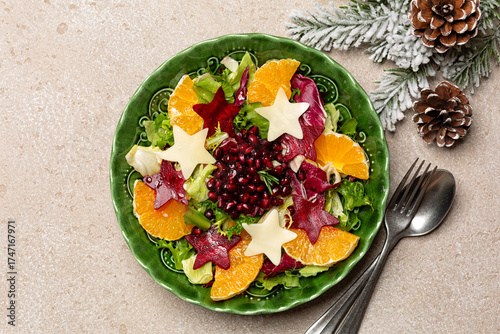Top view of Beautiful festive Christmas and New Year winter salad with star shaped beetroot, oranges, pomegranat and cheese. Healthy food concept.