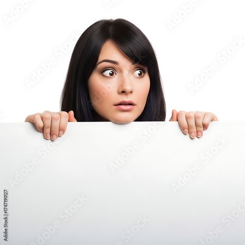 Woman peeking over white blank sign expressing surprise shocked expression isolated on transparent background