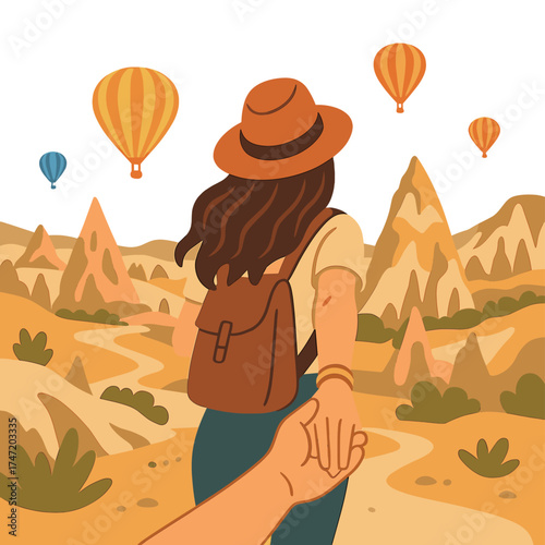 Female travelers guide a man, holding his hand, toward hot air balloons in Cappadocia, Turkey