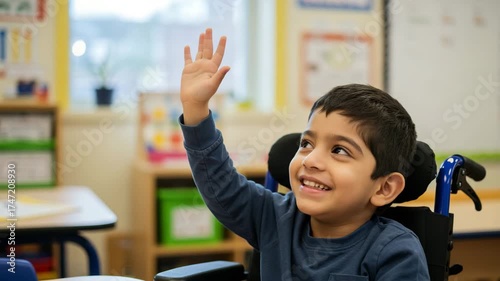 Boy in wheelchair raising hand in classroom, inclusive education and learning support