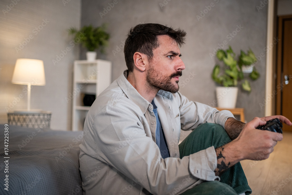 Fototapeta premium Young man playing video game at home