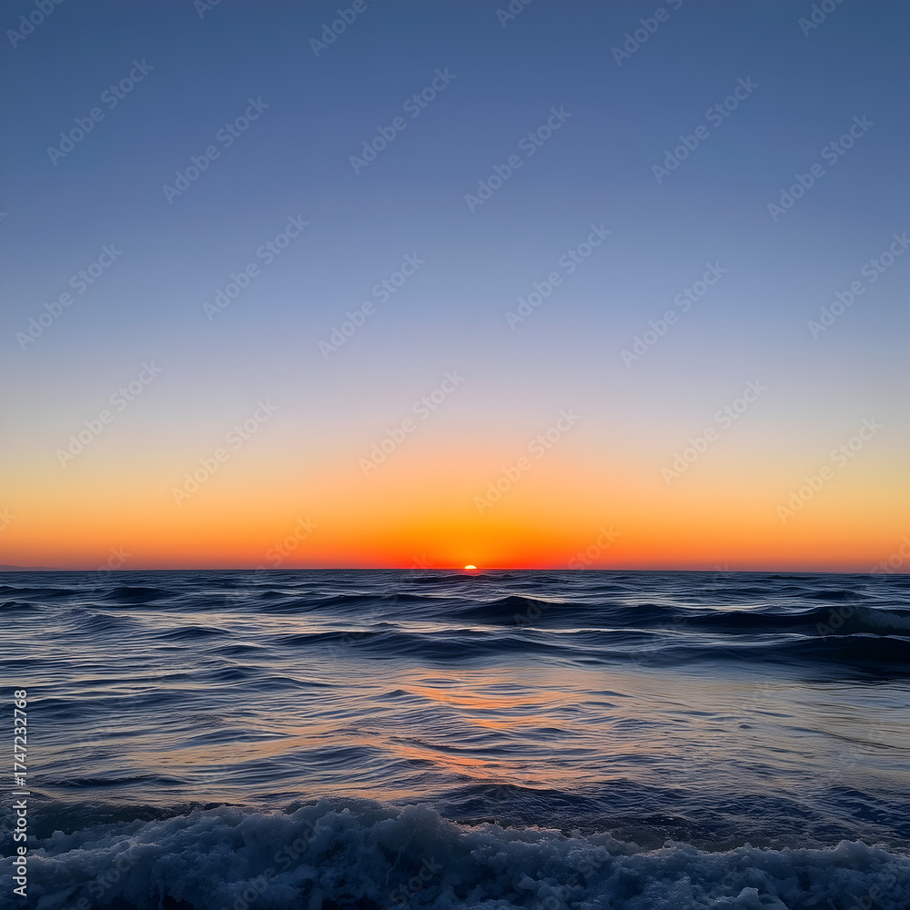 Obraz premium Serene Ocean Sunset with Gentle Waves and Clear Sky