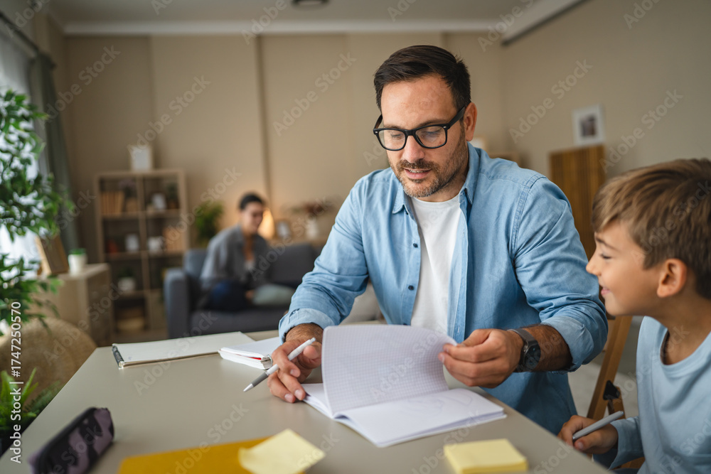 Fototapeta premium Father helping son with homework at home