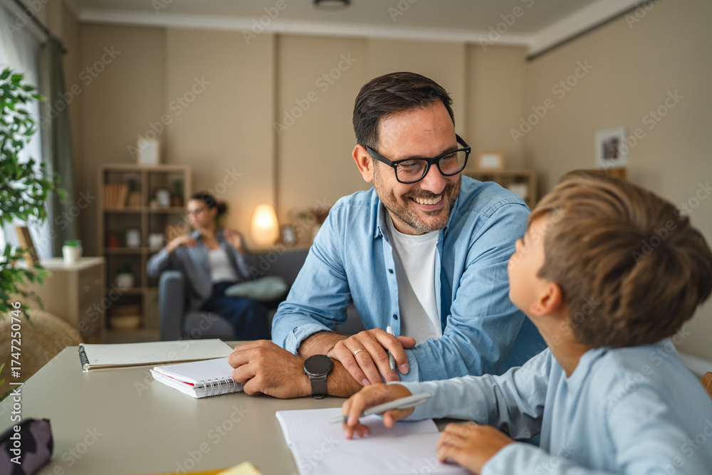 Obraz premium Father helping son with homework, teaching and learning at home