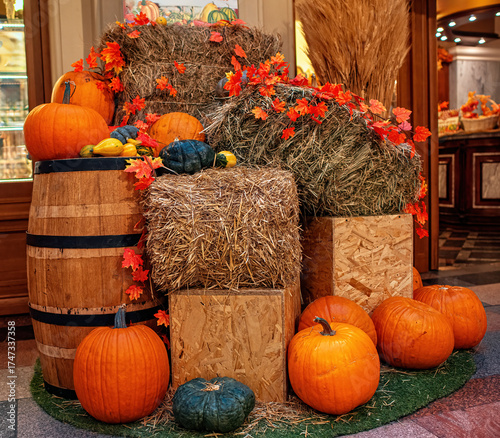 A beautiful composition on the theme of Halloween: pumpkins, rustic carts, bales of straw.