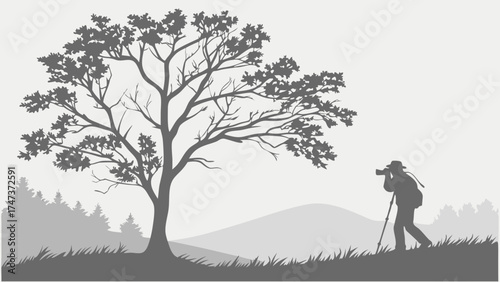 Silhouette of a photographer with a tripod taking pictures of a landscape with trees and hills in grayscale.