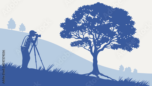 Silhouette of a photographer using a tripod capturing a scenic view of a large tree on a hillside.