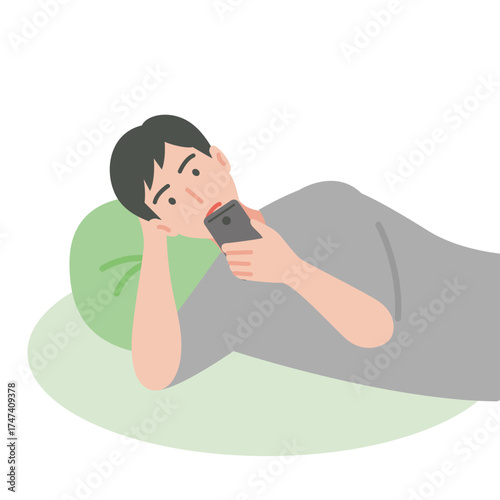 寝そべりながらスマートフォンを使う男性