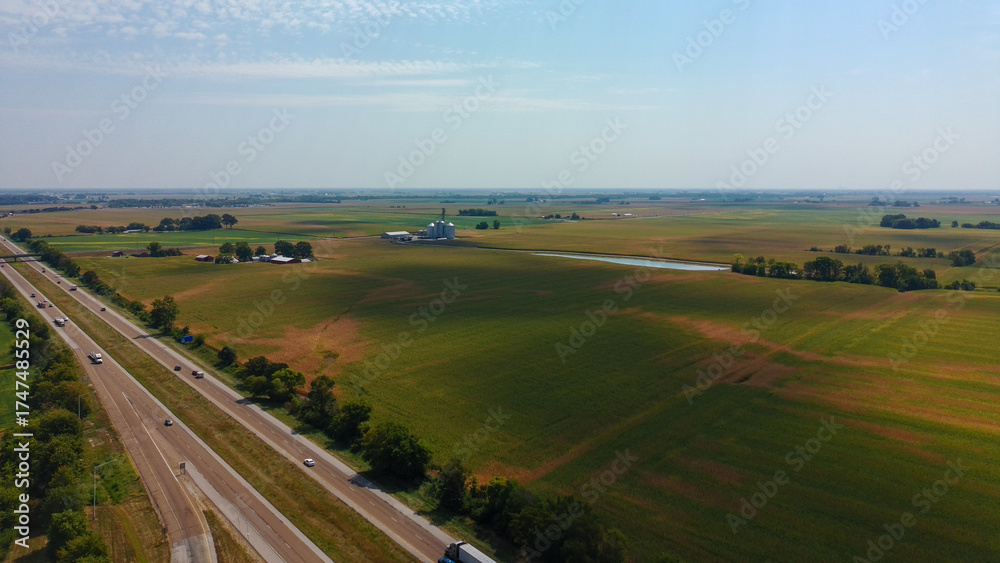 Naklejka premium Drone shot of an interstate highway in the Midwest showing farms and open fields.