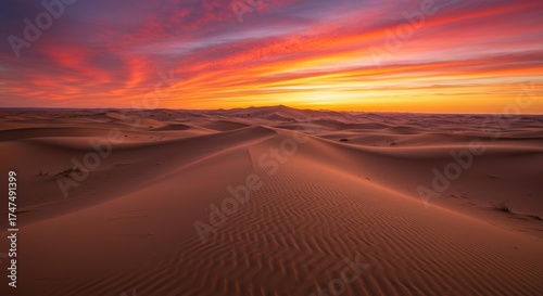 Fototapeta Naklejka Na Ścianę i Meble -  Dramatic desert sunset vivid sky over sand dunes, warm tones
