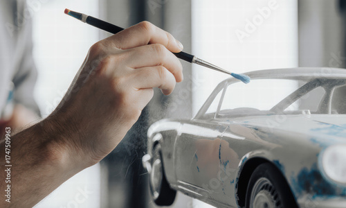 Hobbyist paints a miniature car model with a fine brush