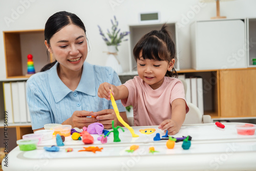 toddler girl with mother sculpting from plasticine at home