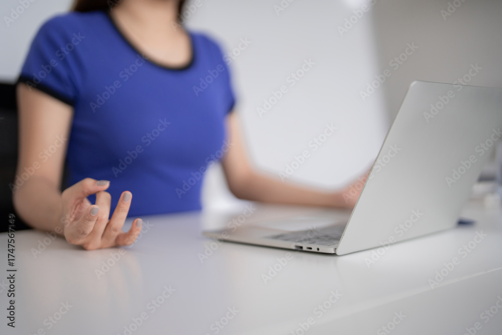 Fototapeta premium Adult Asian woman working remotely on laptop at home office focused on business tasks calm productive