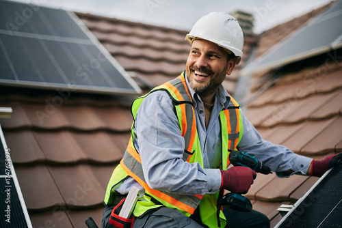 Photos Happy worker mounting solar system on roof of residential building