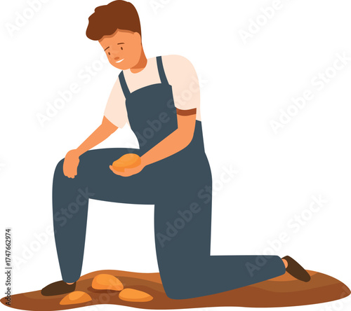 Young farmer kneeling and holding potatoes during harvest time in the field