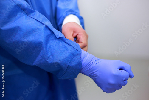 Close-up of a doctor«s hands adjusts his protective gloves