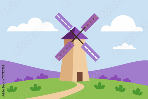 A windmill stands in a field under a cloudy sky