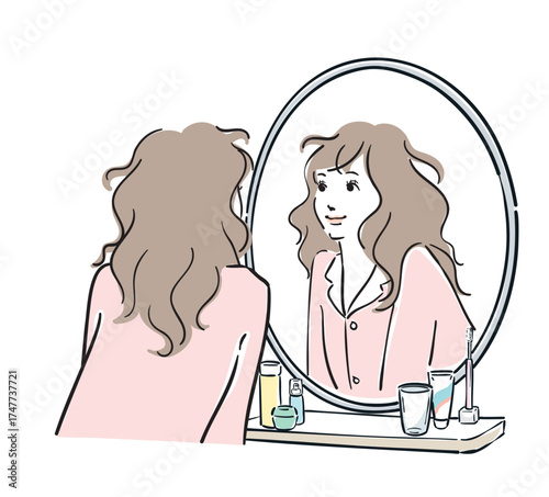 鏡を覗き込むパジャマ姿の女性