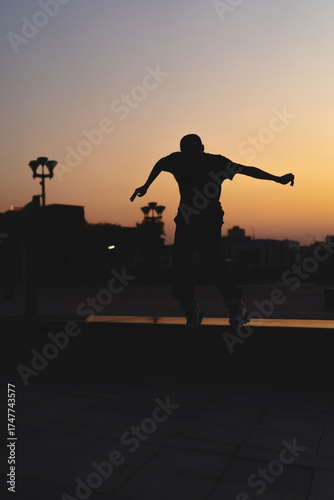 Man performing a trick on roller skates at sunset, urban environment