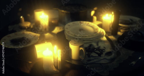 Foto A dimly lit table adorned with flickering candles casts a warm glow on old dinnerware, creating an atmosphere filled with nostalgia and mystery