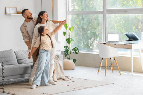 Cute little girl with her parents dancing at home