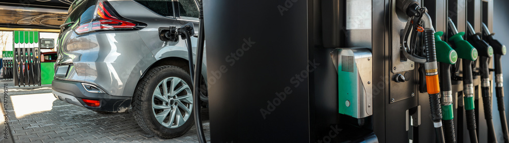 Fototapeta premium Modern car refueling at a gas station