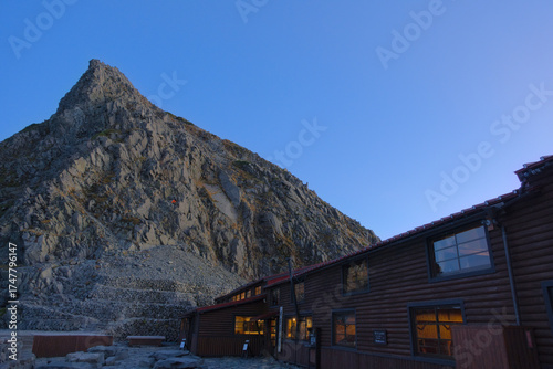 北アルプス、夕暮れの穂高岳山荘と奥穂高岳方面の岩峰