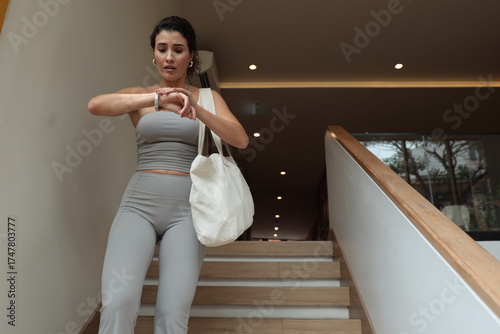 Canvas Print Modern woman standing on staircase, short break before rushing again