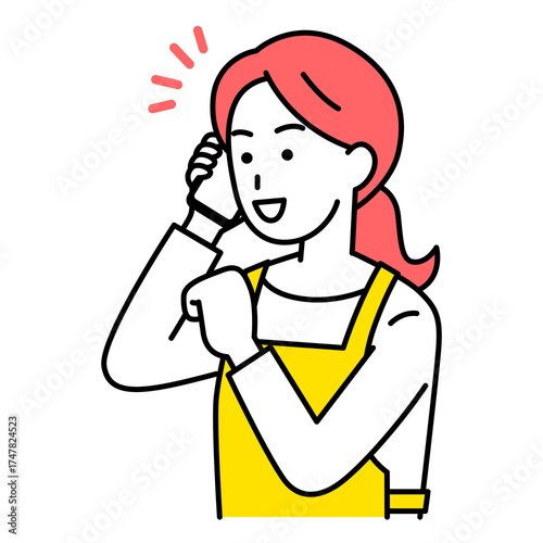 スマートフォンでの通話で喜ぶエプロン姿の女性