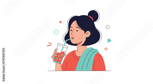 A young woman with dark hair tied in a bun drinks a red beverage with a straw.