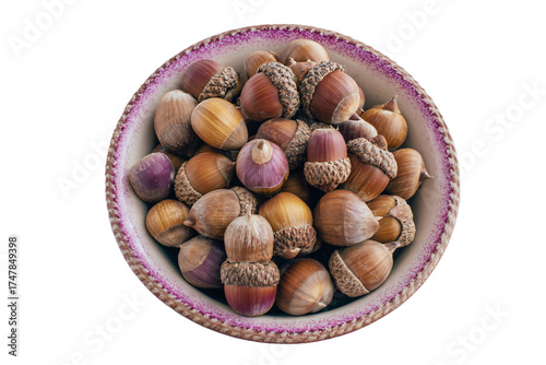 A rustic ceramic bowl filled with a collection of acorns.