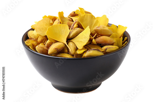 A black ceramic bowl filled with roasted ginkgo nuts and yellow leaves.