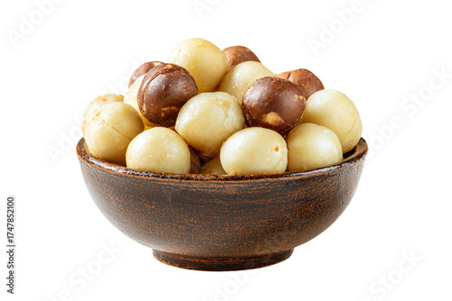 A rustic brown bowl filled with shelled and unshelled macadamia nuts.