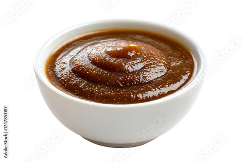 A small white ceramic bowl of thick brown sauce.