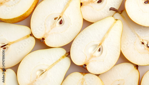 Sliced pears arranged showing white flesh and seeds on white surface
