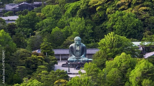Aerial view of the iconic Great Buddha statue surrounded by lush green trees, creating a serene and spiritual landscape, Kamakura, Tokyo, Japan.