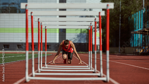 Εκτύπωση καμβά Runner preparing to start hurdle sprint on athletics track under sunlight
