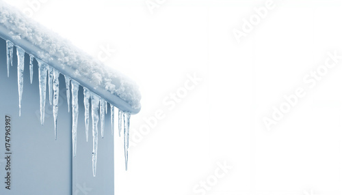 Icicles hanging from snowy roof against white background in winter  , copyspace