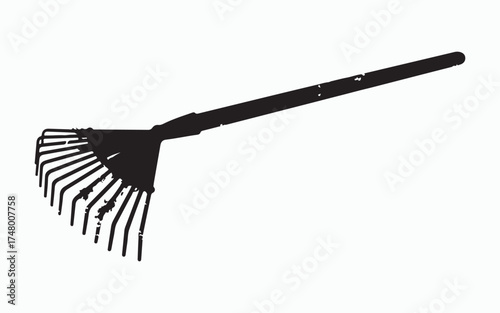 Rake Silhouette in Monochrome: This stark image showcases a silhouette of a rake, a common garden tool, set against a contrasting background, emphasizing its functional form and lines.