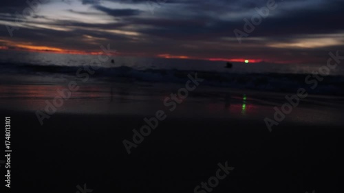 Breathtaking Red Sunset on Thailand Beach - People Relaxing on Shore with Ocean Waves . Stunning ground-level shot of a vibrant red sunset over a tropical beach in Thailand