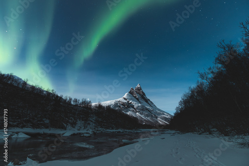 Magical green ribbon of the Aurora Borealis above Otertinden with thousands of stars in the Lyngen Alps region of Northern Norway