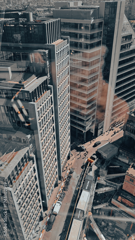Fototapeta premium Aerial view of modern city skyline with tall skyscrapers in sunlight.