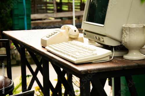 90s telephones and computers are displayed on a table.