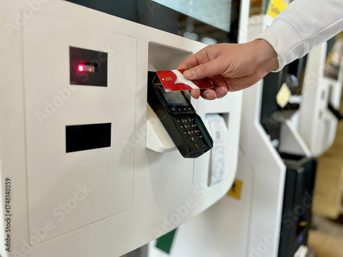Close-up of man paying for takeaway food using bank card contactless payment at self-service kiosk. Concept: cashless payments, modern technology, digital everyday life.