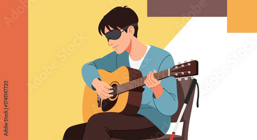 A young blind man wearing sunglasses plays an acoustic guitar while sitting on a chair, with a white cane beside him.