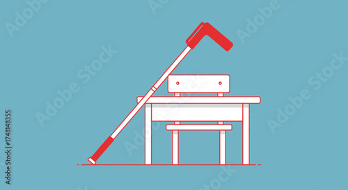 A white cane leans against a school desk and chair, symbolizing education and accessibility for visually impaired students.