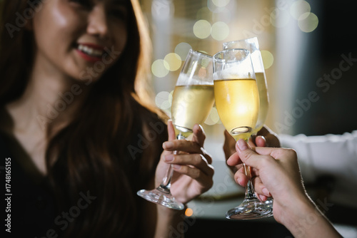 A woman smiling and toasting with a glass of wine during an evening celebration, surrounded by soft bokeh lights and a warm atmosphere.