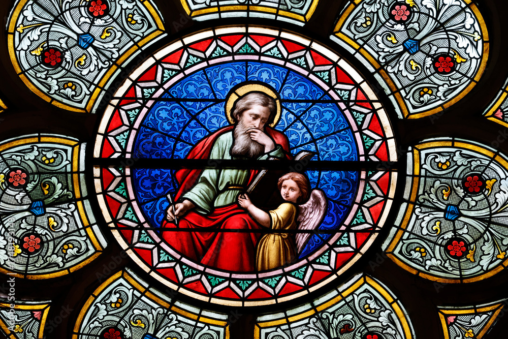 Obraz premium Saint Seine church. Stained glass. Matthew is often symbolized by an angel, representing his focus on the humanity of Christ and the lineage of Jesus. Corbigny. France.
