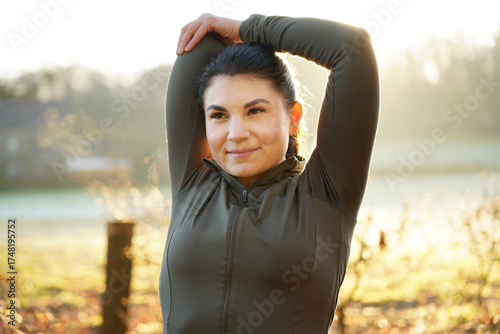 Athletic young woman is stretching after workout, training and running on a beautiful winter morning	

