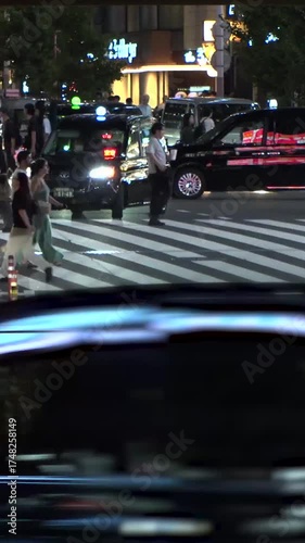 TOKYO, JAPAN - AUG 2025 : Street traffic and crowd of people walking at crossing in busy downtown area. Japanese people, urban city nightlife and lifestyle concept video. Time lapse shot.